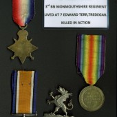 WW1 service medals of Corporal Albert Powles and cap badge of the 3rd Battalion of Monmouthshire Regiment. Corporal Albert Powles