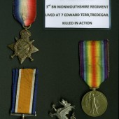 WW1 service medals of Corporal Albert Powles and cap badge of the 3rd Battalion of Monmouthshire Regiment. Corporal Albert Powles